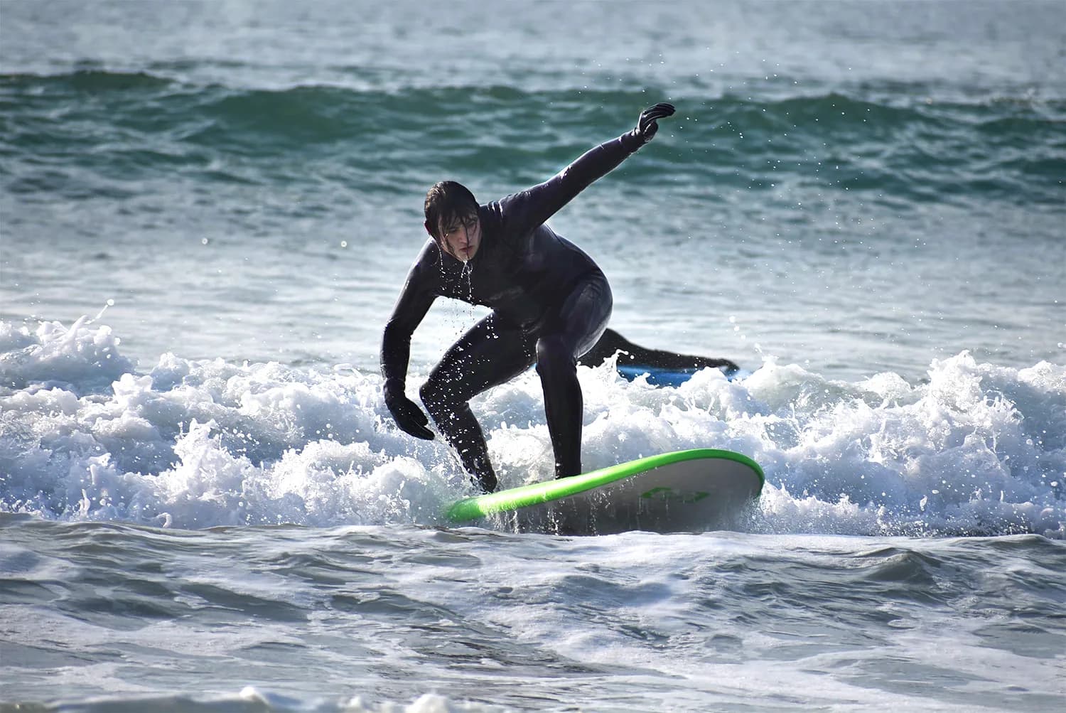 Studente praticando surf sulle onde irlandesi, vivendo un’esperienza unica di sport e natura durante un anno scolastico in Irlanda.